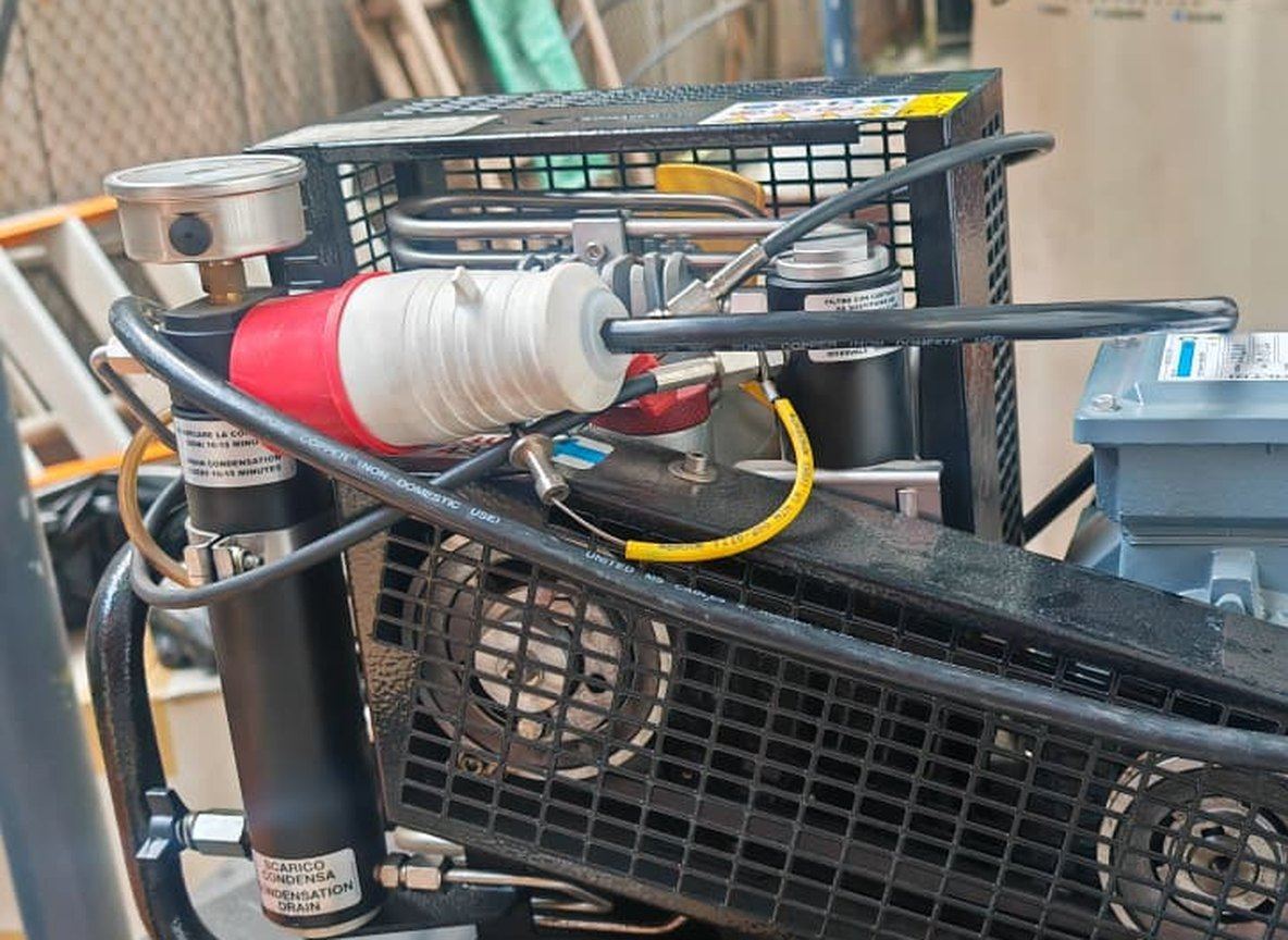Breathing air compressor with gauges and a filter pot